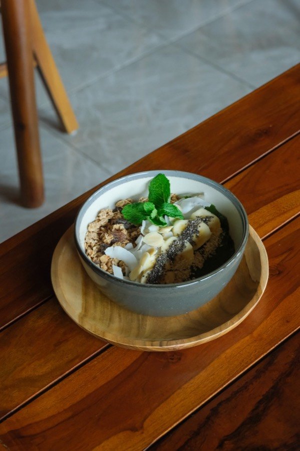 Smoothie bowl with granola, banana, coconut and mint